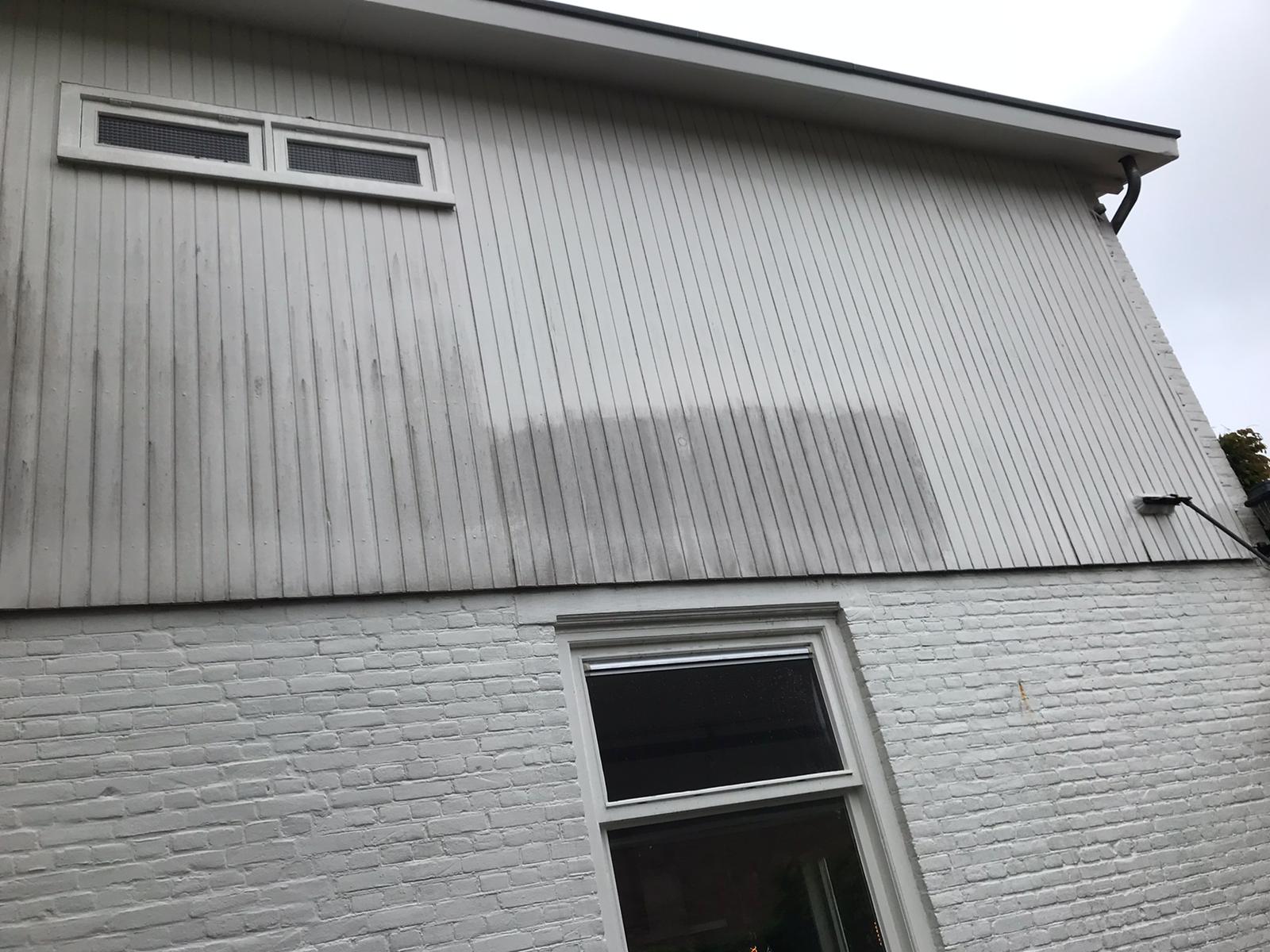 Gevel van een woning, links al gereinigd en rechts nog grauw: voor en na in één foto