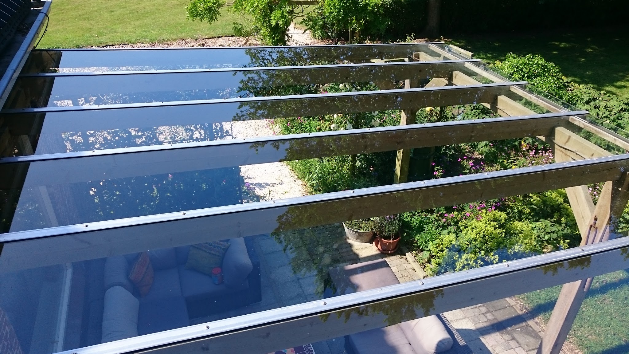 Schoon glazen dak van een veranda boven een terras